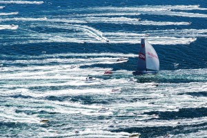 The escort: Wild Oats XI surges up the Derwent River towards Hobart amid a sea of white on her way to a historic eighth line honours victory in the Rolex Sydney Hobart Yacht Race. (Credit: Andrea Francolini/AUDI)